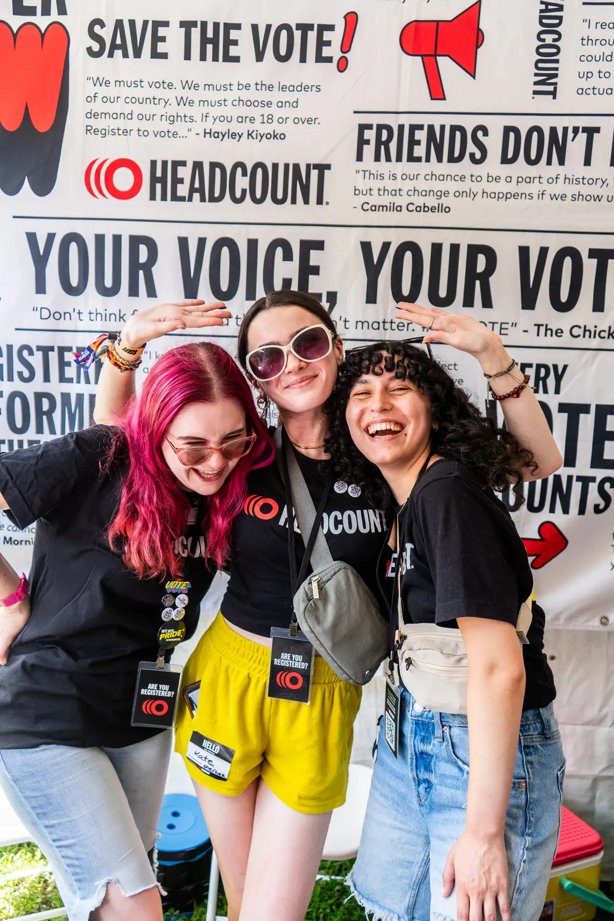 Three volunteers in front of HeadCount step and repeat background